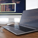 Imagem de um ambiente de desenvolvimento com duas telas: um notebook exibe um código em frontend com foco em interface, enquanto a tela ao fundo apresenta dados de serviços da API em execução. A cena reflete a integração e o monitoramento de APIs em tempo real, destacando o fluxo de comunicação entre sistemas e a importância da API na automação e conectividade. Ideal para ilustrar a interconexão de serviços e a gestão de recursos através de APIs em um ambiente de desenvolvimento.